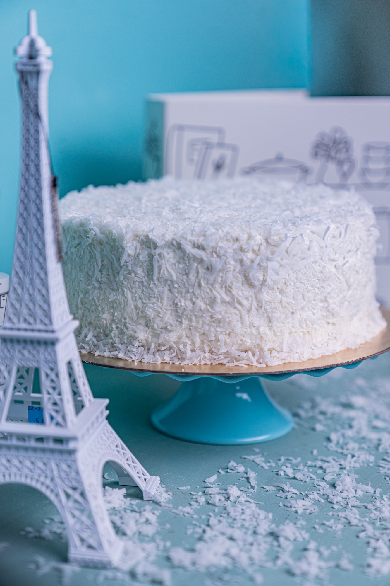 Fully iced coconut cake with a slice cut away